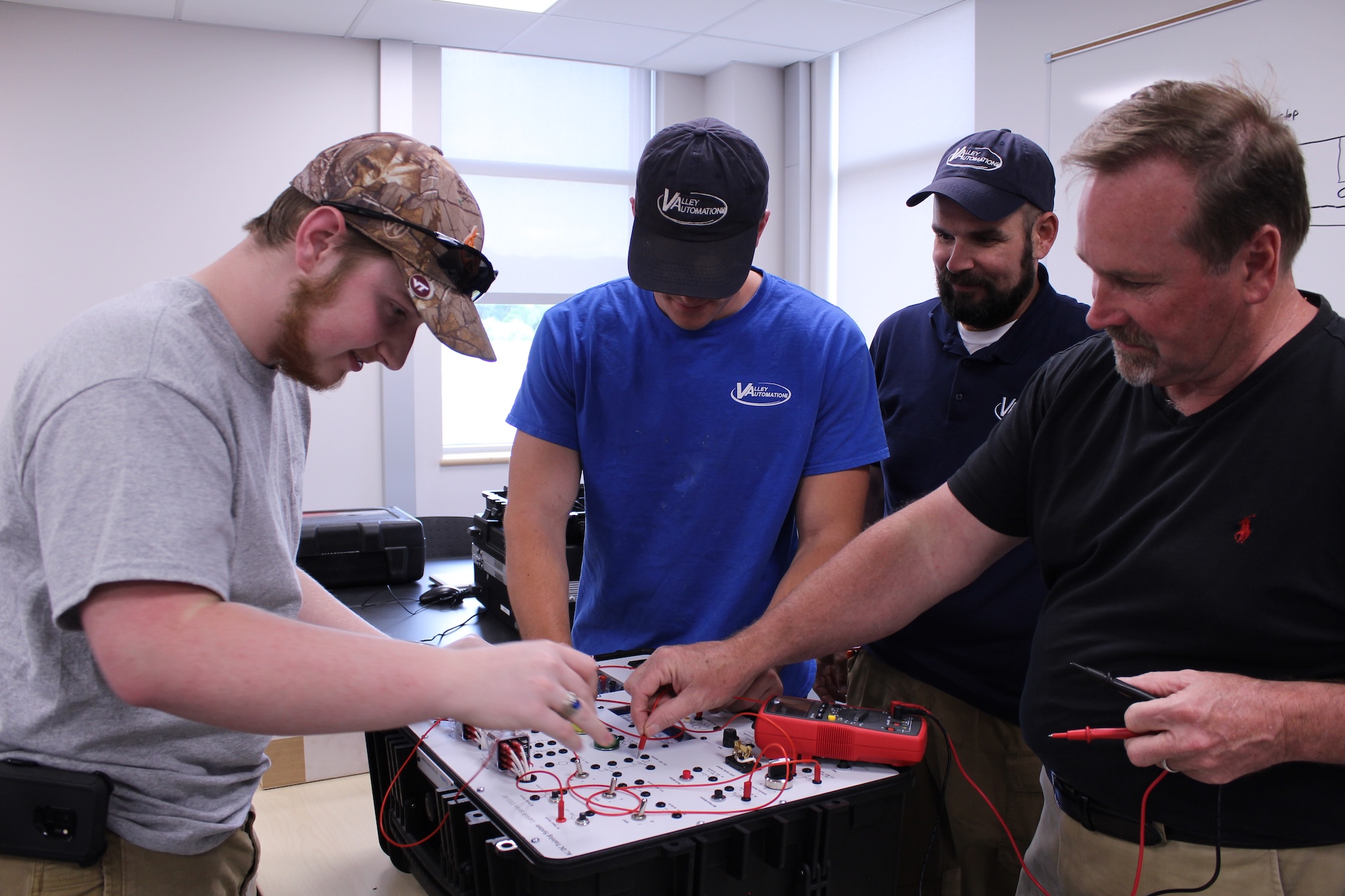 Mechatronics students working together on an electrical training circuit